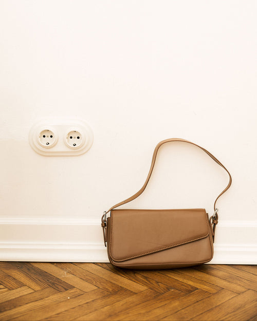Baguette Bag in taupe on wooden floor against white wall