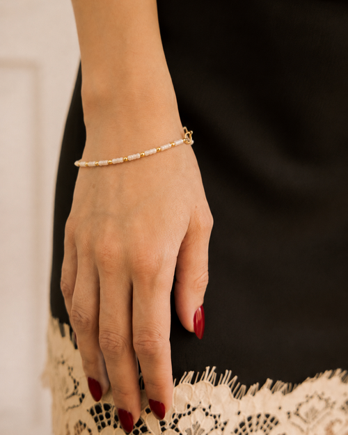 Bracelet with Pearl-Look Beads coiled on vintage silver spoon on lace cloth in silver tray