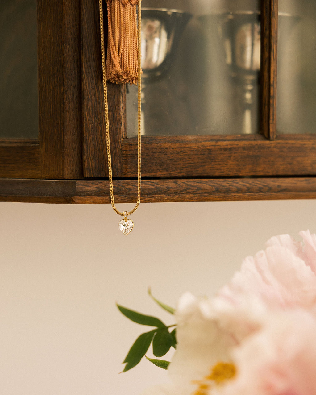 Crystal Heart Necklace worn by model in cream lace top showing heart zircon pendant on snake chain