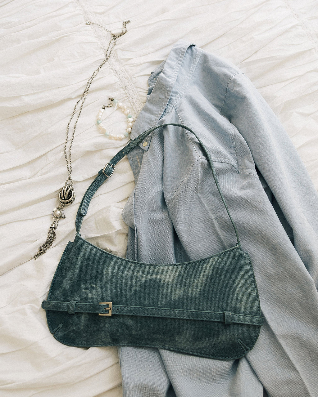 Denim Effect Baguette Bag close-up on white linen showing buckle detail