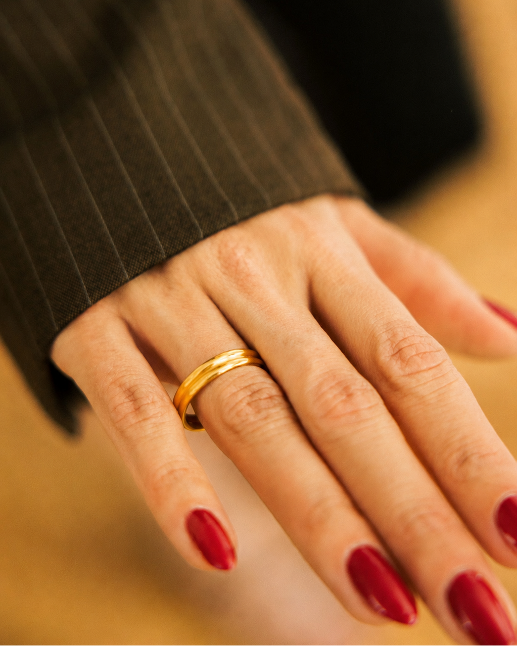 Minimalist dome ring gold-plated worn on hand with dark blazer