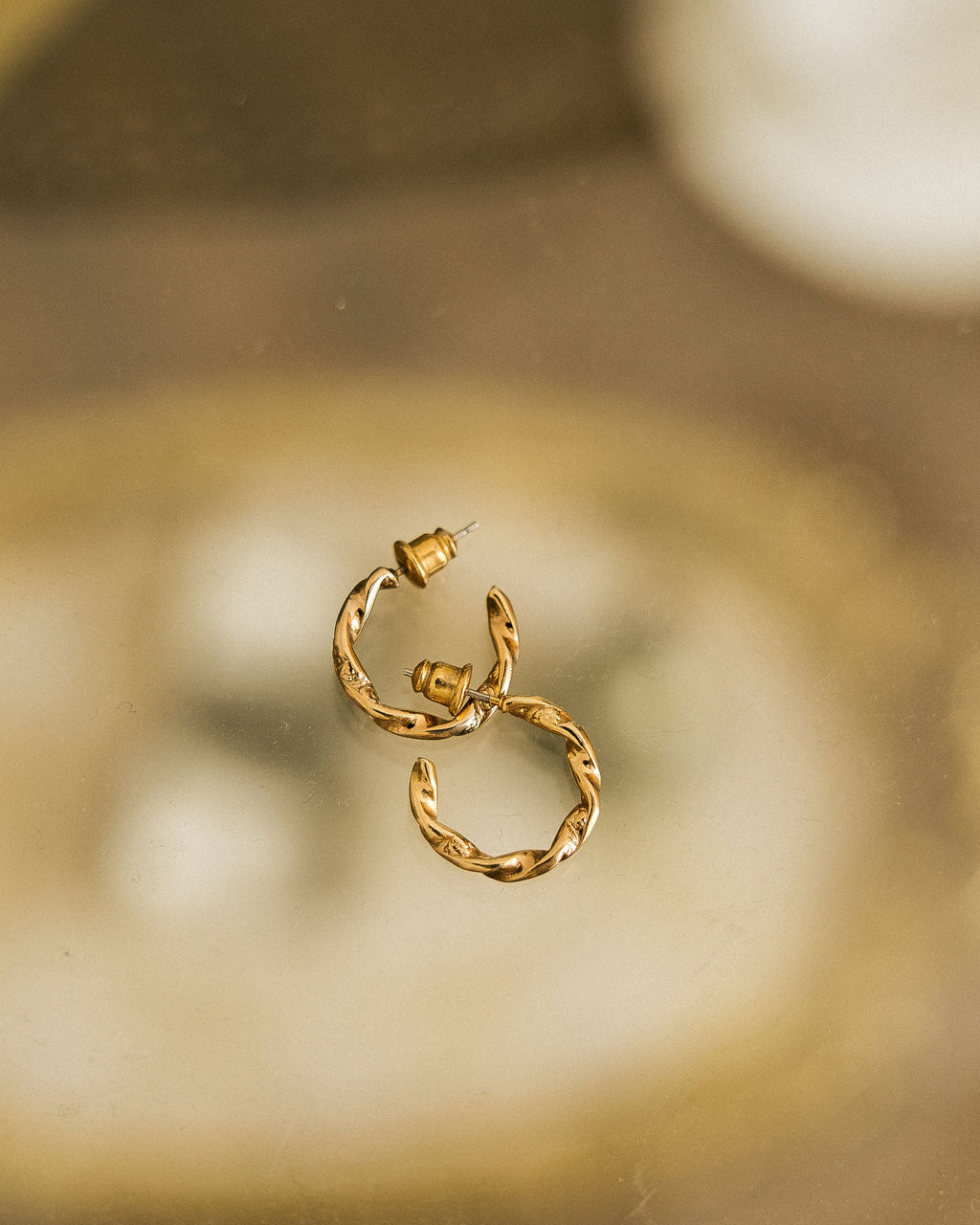 Twisted Gold Hoop Earrings pair on gold vintage tray showing twisted detail