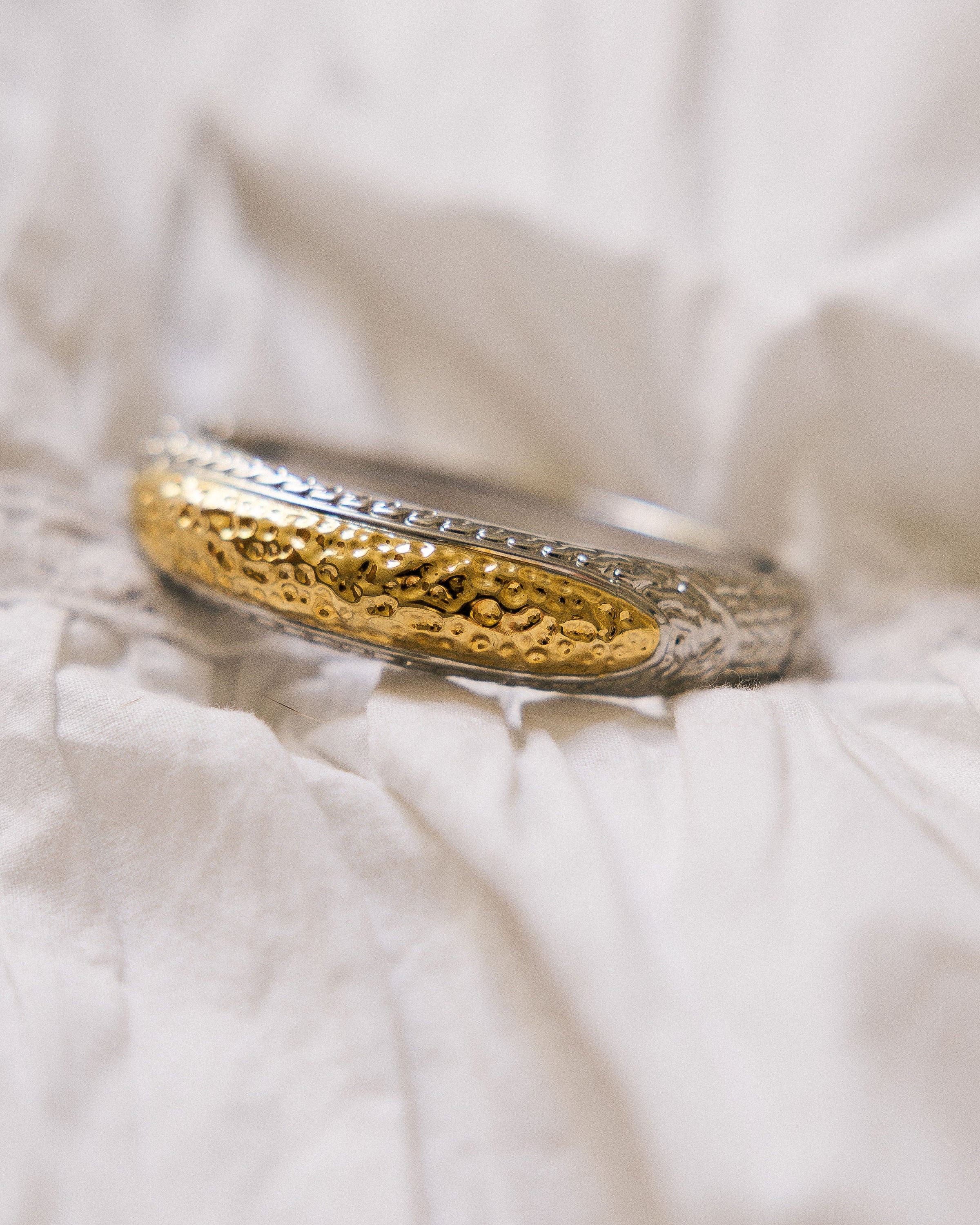 Vintage Two-Tone Textured Bangle close-up on white linen showing hammered gold and silver detail