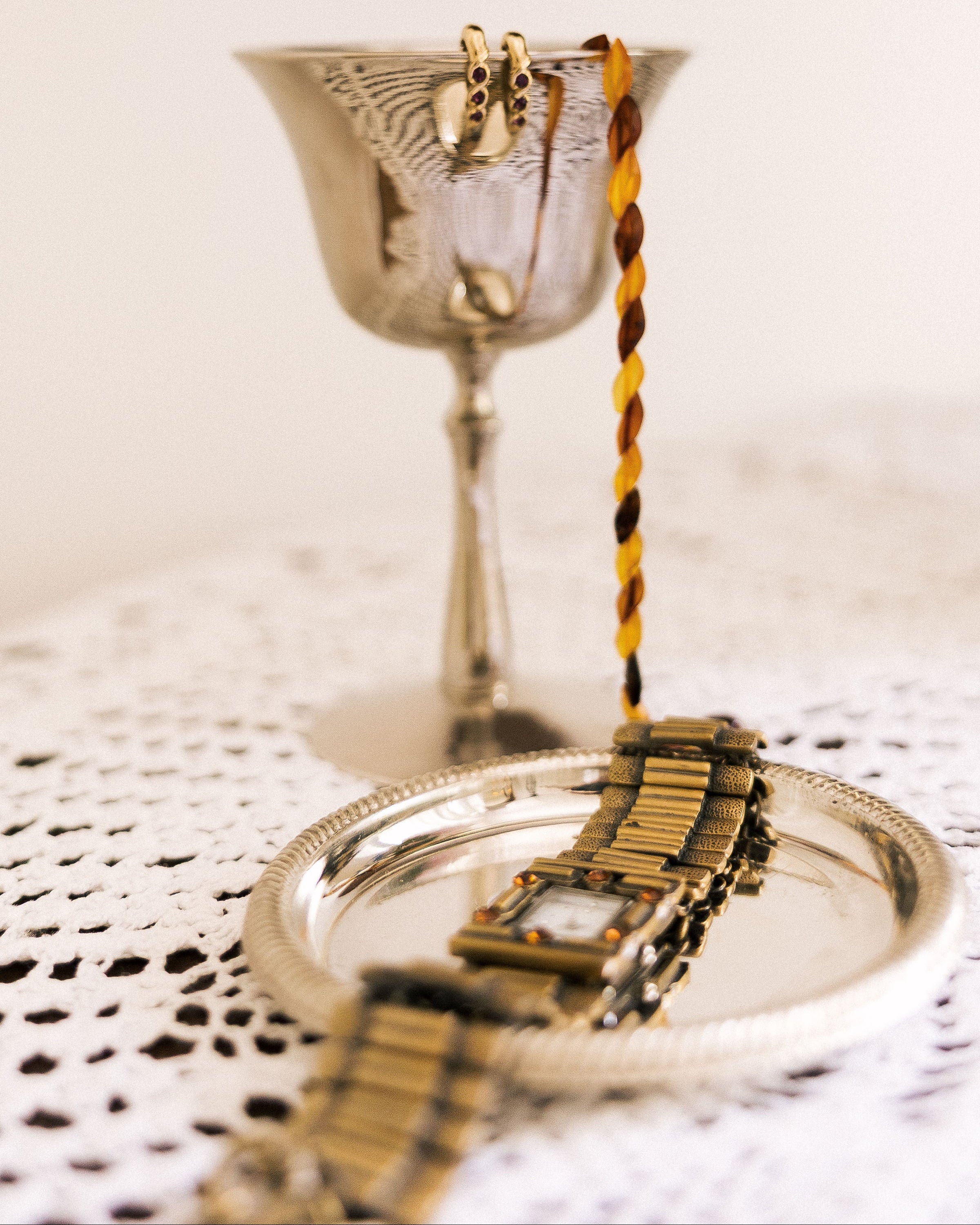 Vintage Watch on silver tray beside silver goblet and Havdalah candle on lace tablecloth